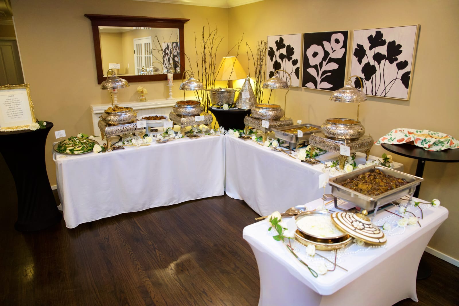 Buffet at a private event — engraved silver chafing dishes on white linen